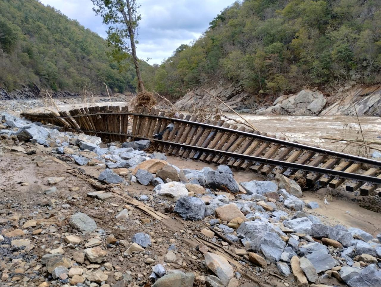 Overturned railroad track with uprooted tree in the river gorge.